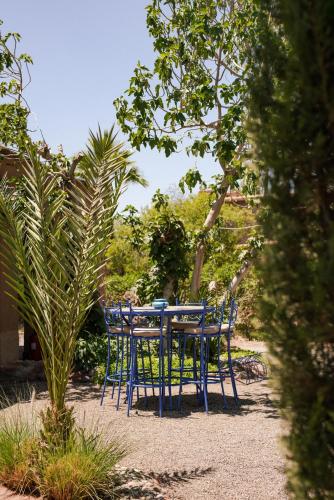 a blue table and chairs in a garden at Jnane Allia in Douar Soukkane