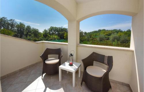 balkon z 2 krzesłami, stołem i oknem w obiekcie Three-Bedroom Holiday Home In Kmacici w mieście Kučići