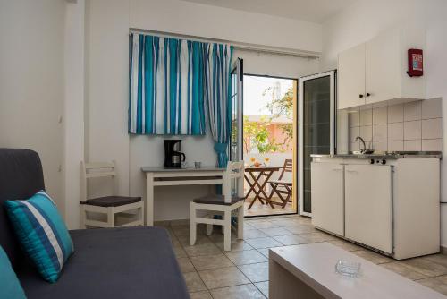 a kitchen and a living room with a couch and a table at Diamond Apartments & Suites in Hersonissos