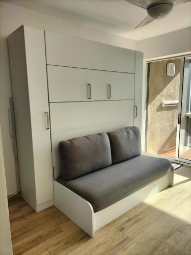 - un canapé dans une pièce avec fenêtre dans l'établissement STUDIO à 200 mètres de la plage, à Canet