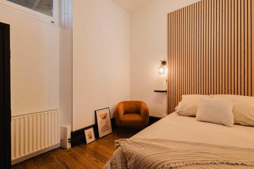 une petite chambre avec un lit et une chaise dans l'établissement Appart design au cœur de Belfort, à Belfort