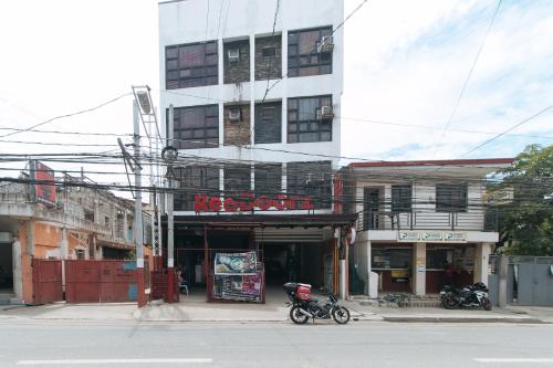 a motorcycle parked in front of a building at RedDoorz at DBuilders Rooms Lower Bicutan in Manila