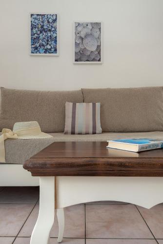 a couch and a table with a book on it at Diamond Apartments & Suites in Hersonissos