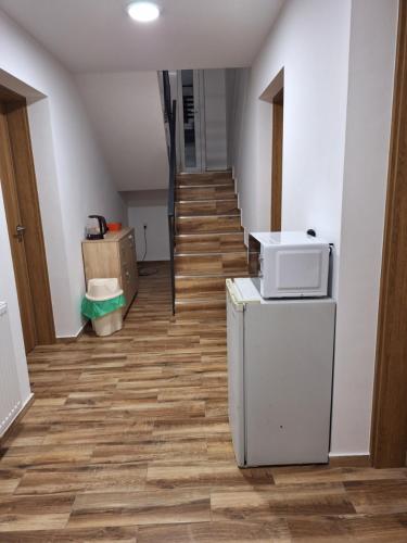 a room with a staircase with a refrigerator and a microwave at BUBO Penzion & Restaurant in Moravany