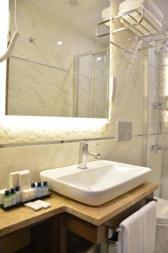 a bathroom with a sink and a mirror at Görükle Güler Park Hotel in Gorukle
