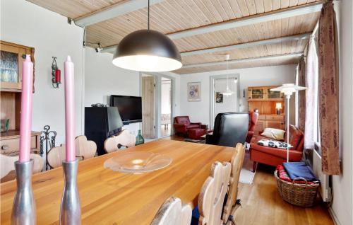 a dining room and living room with a wooden table at Stunning Home In Sejerø With Kitchen in Sejerby