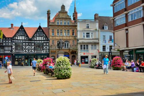 a group of people walking around a city street at 2 Bed Apartment Overlooking the Square Step Out to Shops & Dining in Shrewsbury
