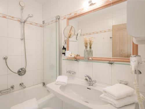 a bathroom with a tub and a sink and a mirror at Apparthotel "Landhaus Veronika" in Mayrhofen