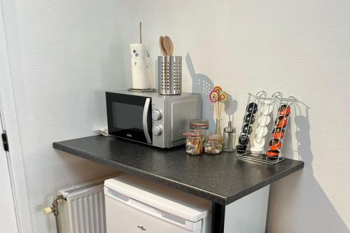 a black counter with a microwave on top of it at Bright, spacious apartment nearby beach in Ostend