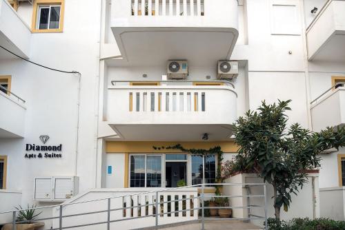 a white building with a staircase leading to the front door at Diamond Apartments & Suites in Hersonissos