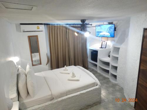 a bedroom with a white bed and a television at Big Boys' Bed & Burger - Patong Beach in Patong Beach