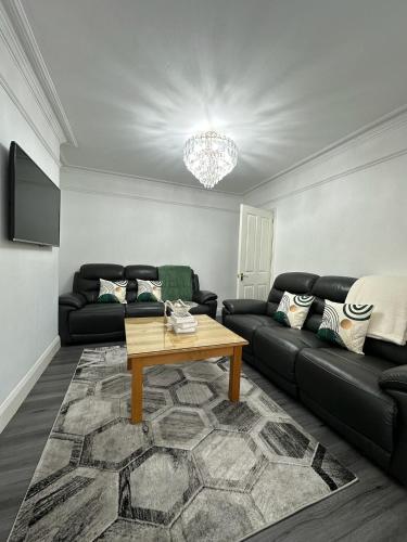 a living room with a black couch and a table at St Helens House Incredible Location with Parking & Garden in Oxford