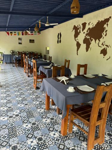 a restaurant with tables and chairs with a map on the wall at Sapphire Garden Hotel in Habarana