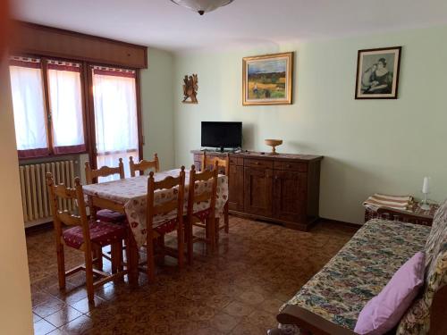 une salle à manger avec une table et une télévision dans l'établissement Monica's apartment Viola, à Sauze dʼOulx