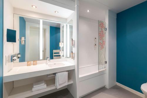 a bathroom with a sink and a mirror at Mercure Lyon Centre Château Perrache in Lyon