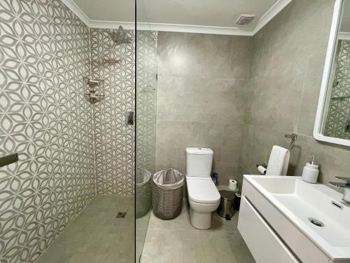 Un baño con ducha, inodoro y lavabo. en Tranquility Place - Goose Valley, en Plettenberg Bay