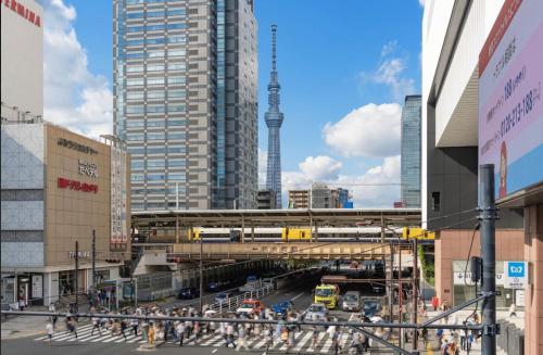 a city with a train crossing a street with buildings at 夏美ホテル in Tokyo