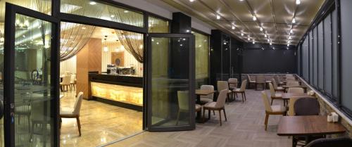 a restaurant with tables and chairs and a bar at Görükle Güler Park Hotel in Gorukle