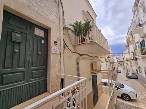a green door on a building with a balcony at Spago rooms in Vieste