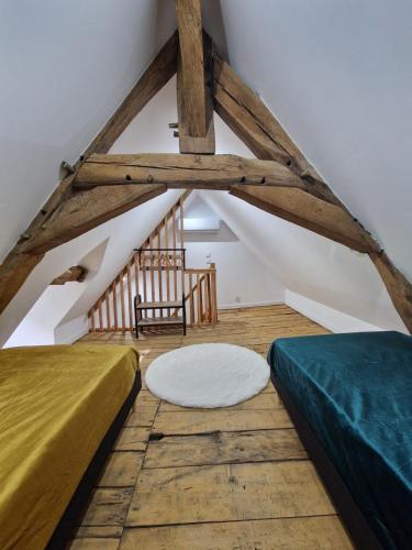 Cette chambre mansardée comprend deux lits et une chaise. dans l'établissement maison 6 personnes, à Bruère-Allichamps