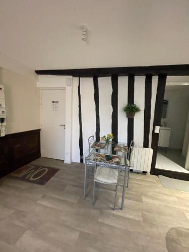 a table and chairs in a room with a wall at Charmant Appartement à Dinan in Dinan