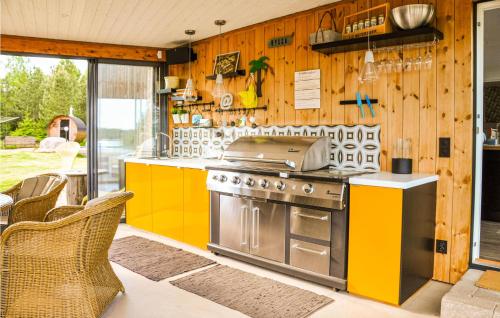 a kitchen with a stove and yellow cabinets at 5 Bedroom Beautiful Home In Karlstad in Karlstad