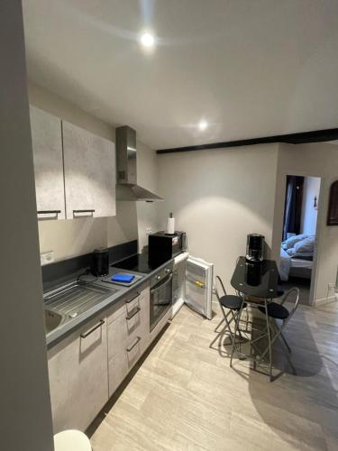 a kitchen with a table and chairs in a room at Charmant Appartement à Dinan in Dinan