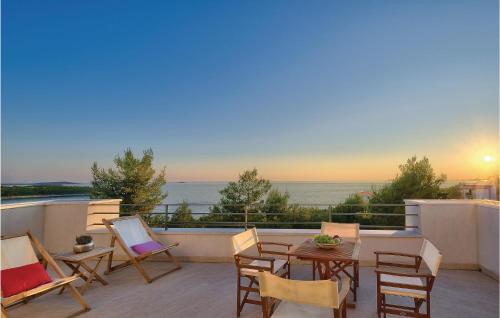 a patio with chairs and a table on a balcony at Holiday Home Primosten-Dolac With Outdoor Pool in Podgreben