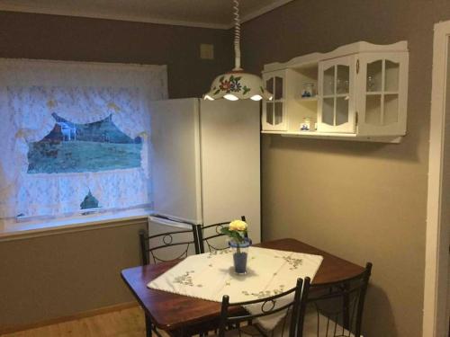 Una cocina con una mesa con sillas y un refrigerador. en Oceanview House Ideal for Peaceful Holidays, en Venøya