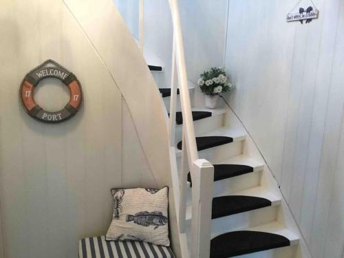 escalera de caracol con espejo y silla en Oceanview House Ideal for Peaceful Holidays, en Venøya