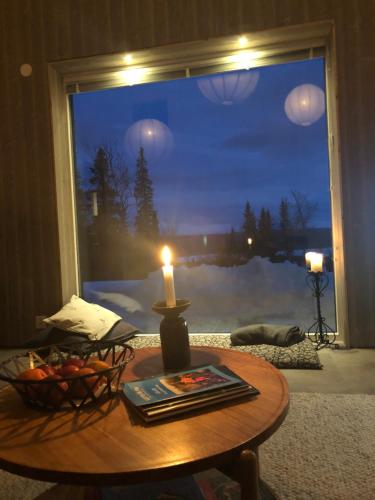 a candle sitting on a table in front of a window at Mountain Holiday Homes - Ottsjö, Trillevallen -Sweden in Åre