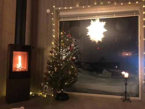 a christmas tree in a living room with a window at Mountain Holiday Homes - Ottsjö, Trillevallen -Sweden in Åre