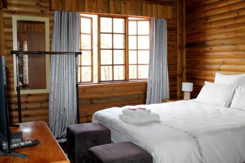 Una cama o camas en una habitación de Ndlovu Log Home Dinokeng