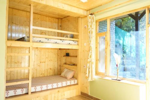 a sauna with a window in a wooden house at Rustic Roots Home Stay in Nagar