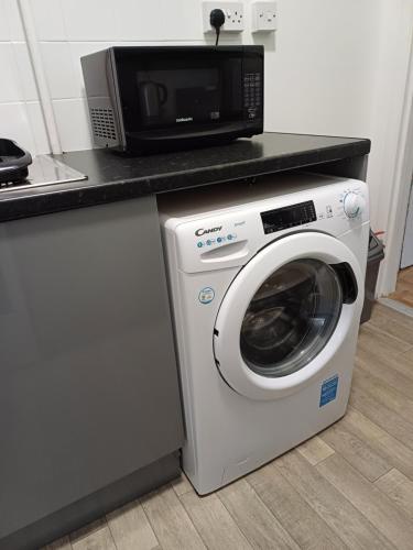 a microwave and a washing machine in a kitchen at Home from Home in Faversham