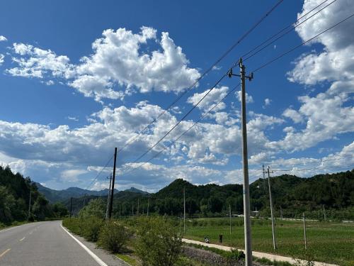 an empty road with clouds in the sky at Huifangge Folk Inn in Miyun