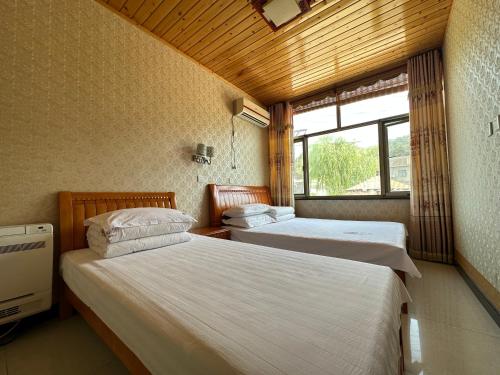 Rúm í herbergi á Huifangge Folk Inn