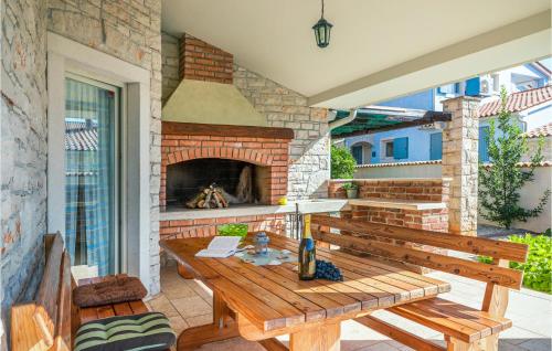 patio con tavolo in legno e camino di Four-Bedroom Holiday Home In Golubovo a Mednjan