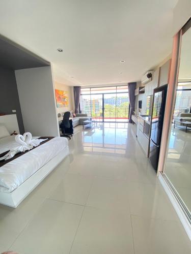 a bedroom with a bed and a living room at Stunning 60 sqm Studio at NaiHarn Beach Condo, Walk to Beach, Your Tropical Retreat! in Rawai Beach
