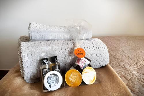 a bed with white towels and products on it at Acesso à Praia Ar Condicionado Conforto Garantido! in Saquarema