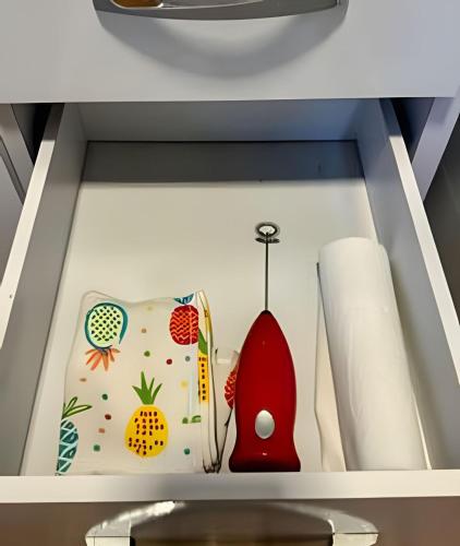 a drawer with a shelf with a book with fruits and vegetables at Acesso à Praia Ar Condicionado Conforto Garantido! in Saquarema