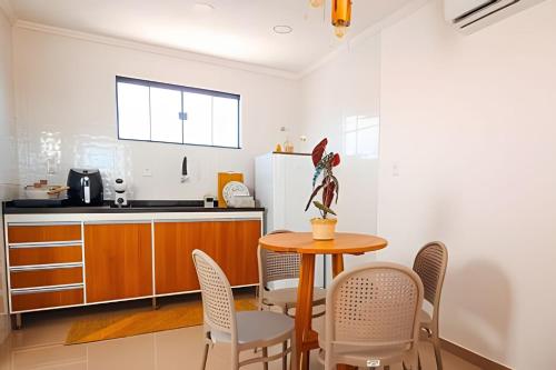 a kitchen with a table and chairs in a room at Acesso à Praia Ar Condicionado Conforto Garantido! in Saquarema