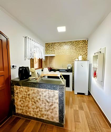 a kitchen with a counter and a refrigerator at Acesso à Praia Ar Condicionado Conforto Garantido! in Saquarema