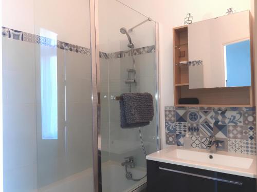 łazienka z przeszkloną kabiną prysznicową i umywalką w obiekcie L'artistique, 4 lits, 2 chambres, stationnement gratuit, spacieux, atypique w Amiens