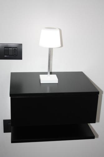 a black desk with a lamp on it at The One Malpensa Rooms in Vizzola Ticino