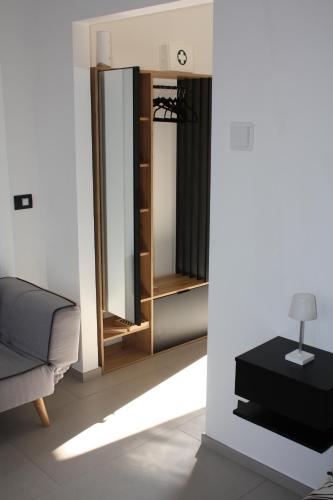 a living room with a couch and a mirror at The One Malpensa Rooms in Vizzola Ticino