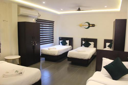 a hotel room with two beds with white sheets at Udupi Comforts in Udupi