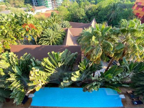 an aerial view of a resort with palm trees and a swimming pool at Stunning 60 sqm Studio at NaiHarn Beach Condo, Walk to Beach, Your Tropical Retreat! in Rawai Beach