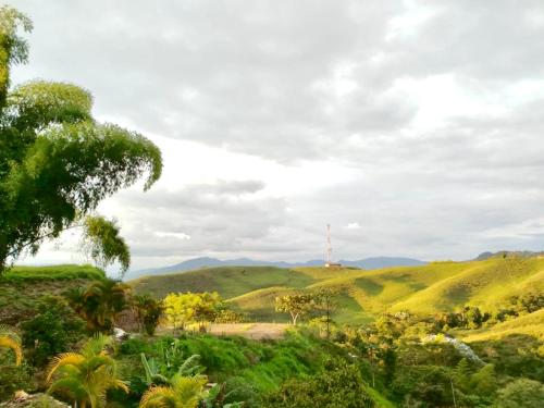 a view of the hills with a radio tower in the distance at Green Highland Casa Campestre in Pereira