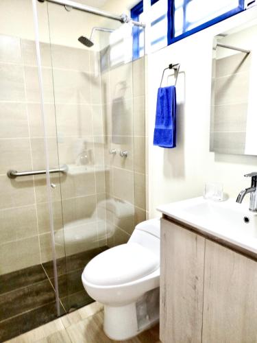 a bathroom with a toilet and a sink and a shower at Green Highland Casa Campestre in Pereira